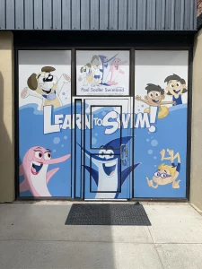 Perforated View Through Window Graphics For Paul Sadler Swimland. This is part of SignKore's Window/Vinyl Lettering collection, featuring window lettering, vinyl lettering, window graphics, storefront window signs, glass decals.