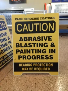 This image shows caution blasting sandwich board sign.