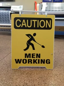 caution men working sandwich board sign